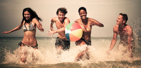 jóvenes jugando con balón de playa publicitario