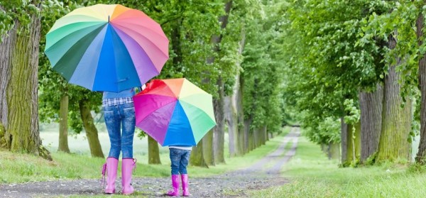 madre e hija con paraguas de colores en el campo