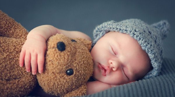 Bebé dormido con oso de peluche