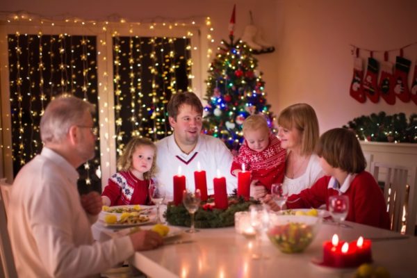 Familia en la mesa vistiendo jerséis navideños